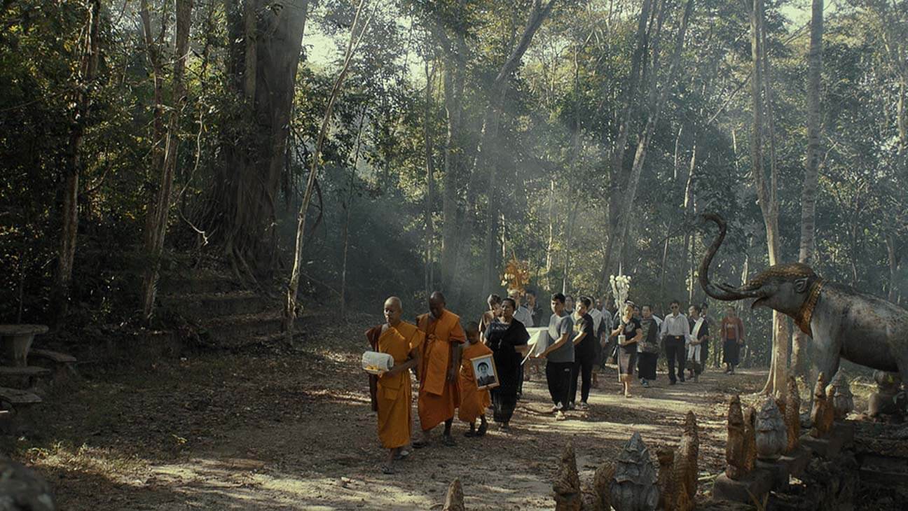 A Laos Buddhist funeral procession through the forest